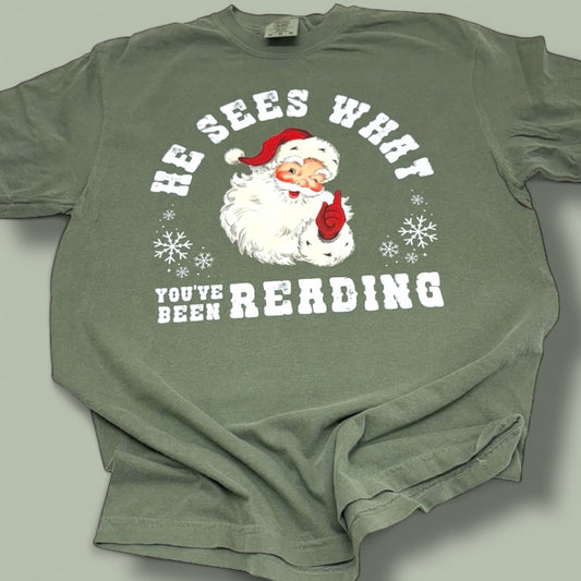 He Sees What You’ve Been Reading Santa T-Shirt